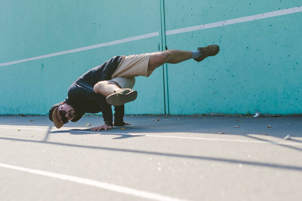 BBOY bailando breakdance contra una pared azul - Foto, imagen