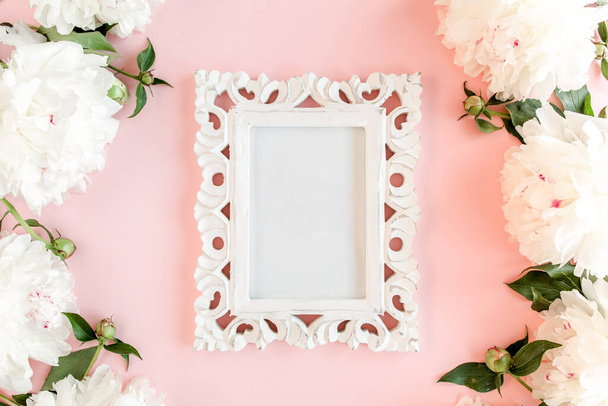 Carved, white frame decorated of white peony flowers on pink background. Peony texture. Flat lay, top view.  - Фото, изображение
