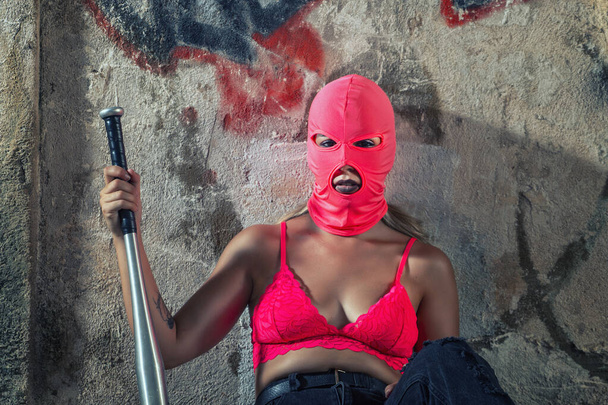 Terk edilmiş bir fabrikada yarasa ve kar maskeli tehlikeli bir kız.. - Fotoğraf, Görsel