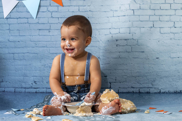 リボンとレンガの壁紙とパンケーキで構成されたセットで1年間の赤ちゃんの男の子のためのパーティー. - 写真・画像