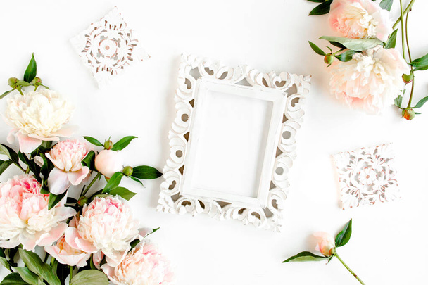 Carved, white frame decorated of beautiful pink peonies on white background. Flat lay, top view. Valentines background. Floral frame. Peony texture. - Фото, зображення