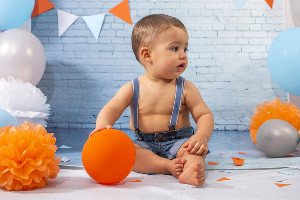 Puolue yhden vuoden vauva poika joukko koostuu ilmapalloja, nauhat, ja tiili seinäpaperi. - Valokuva, kuva