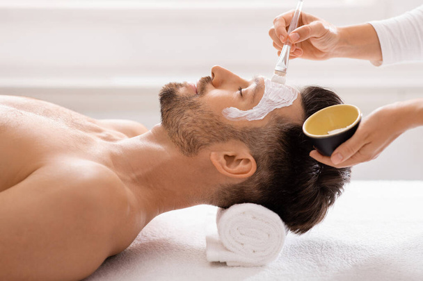 Man krijgt gezichtsbehandeling in spa salon - Foto, afbeelding