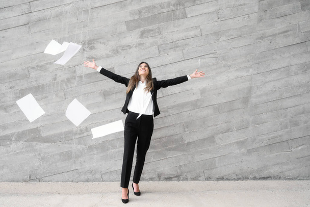 Empresaria lanzando documentos de papel con felicidad celebrando el éxito.  - Foto, Imagen