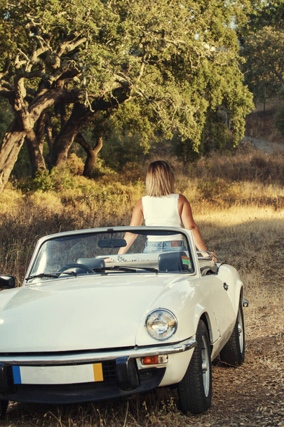 Mulher com carro vintage conversível branco no campo, em posar estilo de vida elegante. - Foto, Imagem