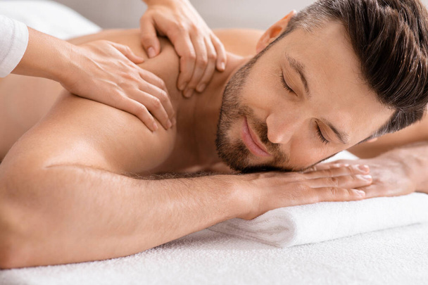 Primo piano di un uomo rilassato con massaggio al corpo al centro benessere - Foto, immagini