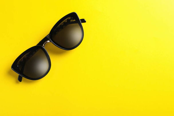 Stylish sunglasses on yellow background, top view. Space for text - Fotoğraf, Görsel