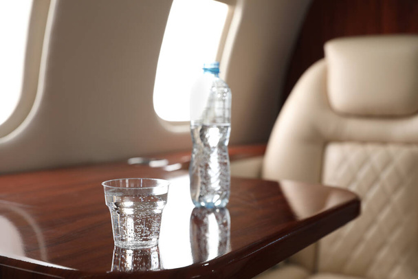 Glass and bottle with water on plane. Comfortable flight - Photo, Image