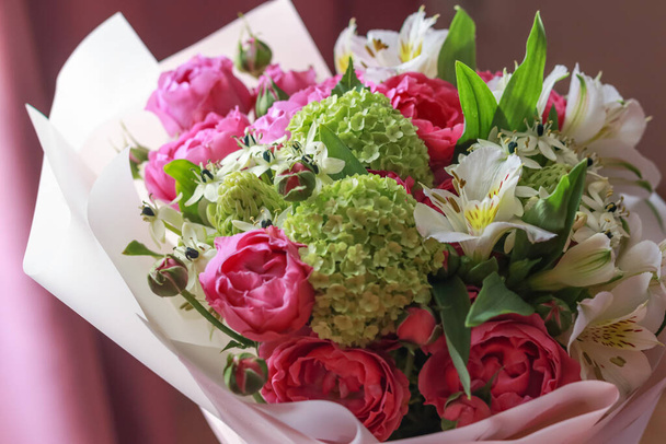 Buquê rosa-verde de rosas, lírios brancos, hortênsias em um fundo roxo - Foto, Imagem