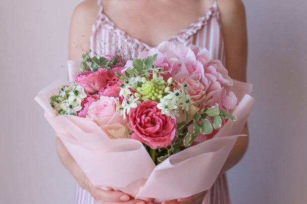 Girl in a pink sundress holds a pink green bouquet in her hands - Foto, Imagem