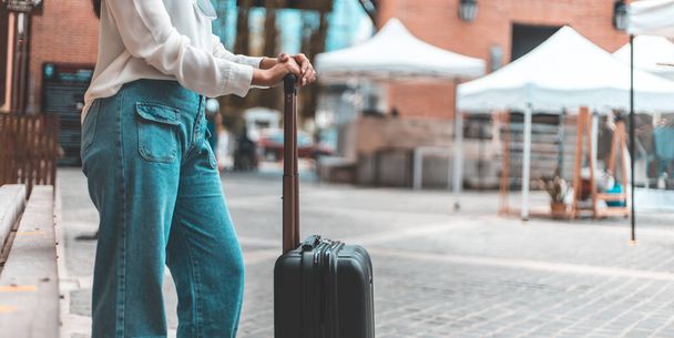 Ασιάτισσα γυναίκα που μεταφέρουν μια μεγάλη μαύρη τσάντα για να ταξιδέψουν κατά τη διάρκεια των διακοπών του έτους, Trolley τσάντα, Long Σαββατοκύριακο ταξίδια, Love the trip, Τουρισμός έννοια φεστιβάλ. - Φωτογραφία, εικόνα