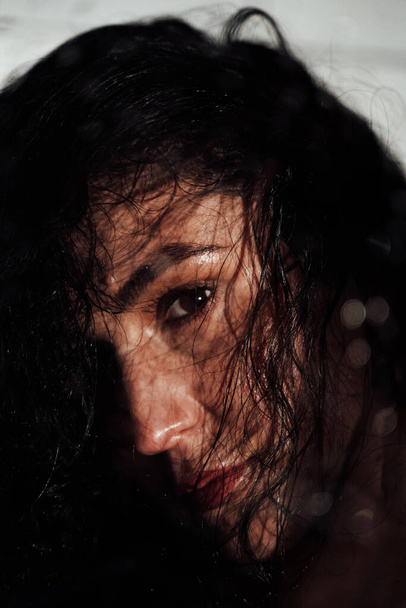Femme brune rêveuse aux cheveux ondulés et au visage transpirant - Photo, image