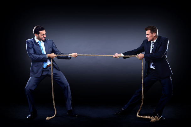 Two business men pulling rope in a competition, isolated on white background - Fotó, kép