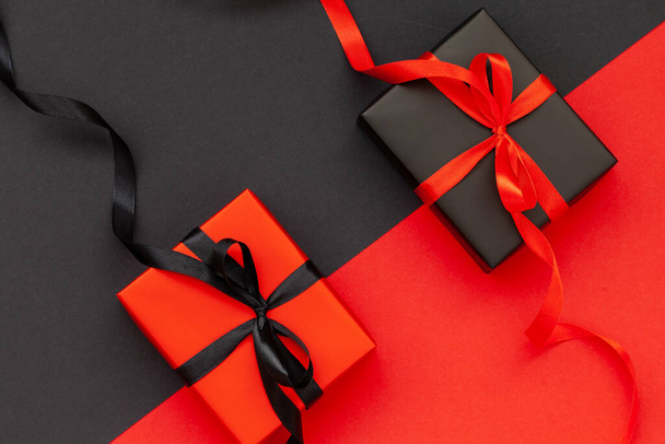 Black Friday concept. Black gift box with red ribbon and red present box with black ribbon. Flat lay - Photo, Image