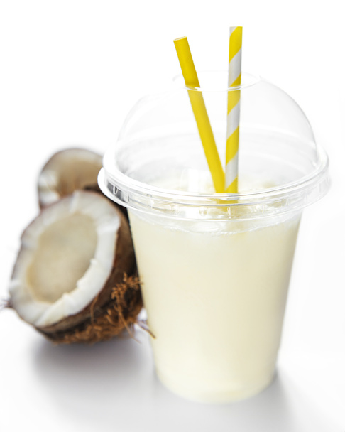 Pina colada alcoholische verse cocktail koud geserveerd met kokosnoot en banaan op een witte achtergrond - Foto, afbeelding