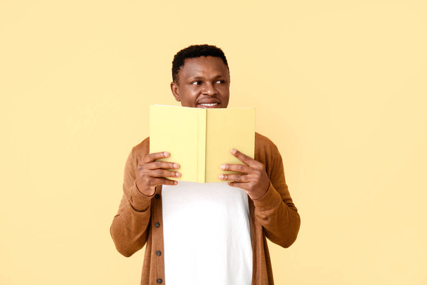 Αφρο-Αμερικανός άνθρωπος ανάγνωση βιβλίο για φόντο χρώμα - Φωτογραφία, εικόνα
