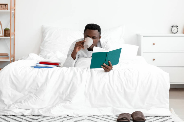 African-American man reading book at home - Fotó, kép