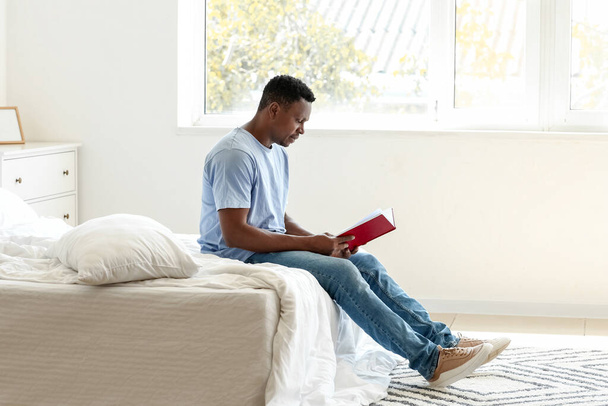 Αφρο-Αμερικανός άνθρωπος ανάγνωση βιβλίο στο σπίτι - Φωτογραφία, εικόνα
