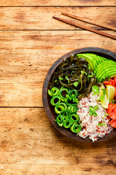 Poke bowl with salmon and vegetables on wooden table - Fotografie, Obrázek