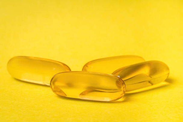 Close-up of Omega-3 capsules isolated on yellow background - Photo, Image