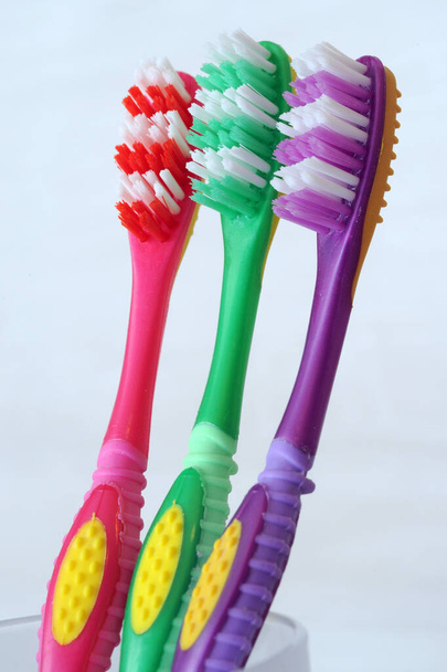 Зубная щетка красный зеленый и фиолетовый - зубные щетки различных цветов для гигиены полости рта стоматолога и профилактики кариеса стоматологическая чистка - Фото, изображение