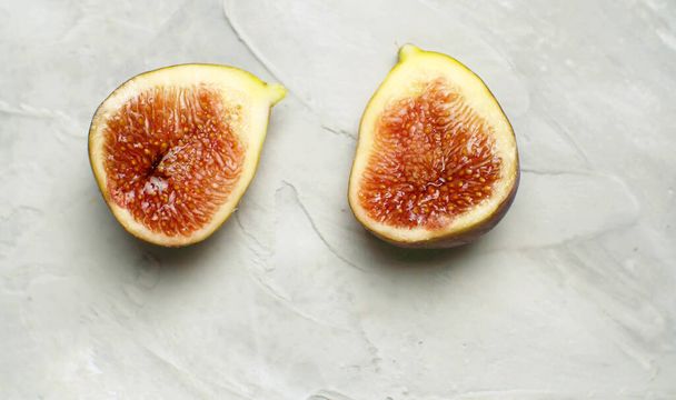 Macro shot halves of ripe fig on the table on white background. Healthy fresh food concept - Φωτογραφία, εικόνα