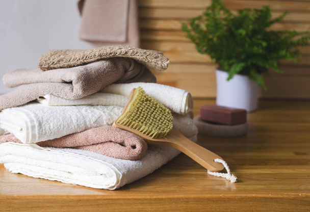 Pila di asciugamani in spugna in diverse tonalità di marrone e bianco all'interno, accessori per il lavaggio, immagine orizzontale, messa a fuoco selettiva - Foto, immagini