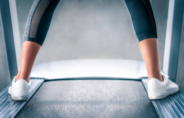 gambe runner indoor è in piedi sul lato del tapis roulant durante il riposo da esercizio di jogging. - Foto, immagini