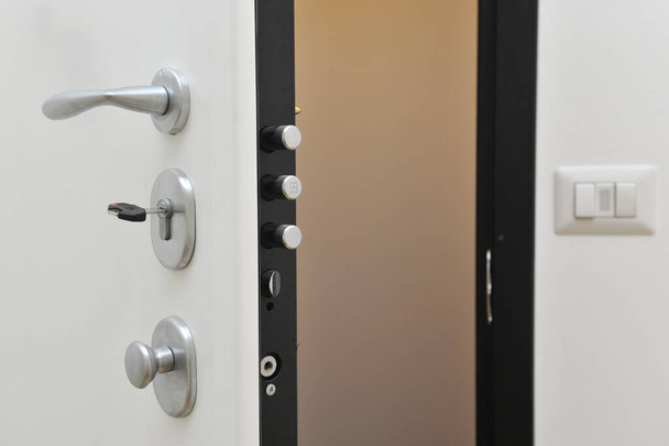 bílé otevřené dveře s klikou a zámkem  - Fotografie, Obrázek