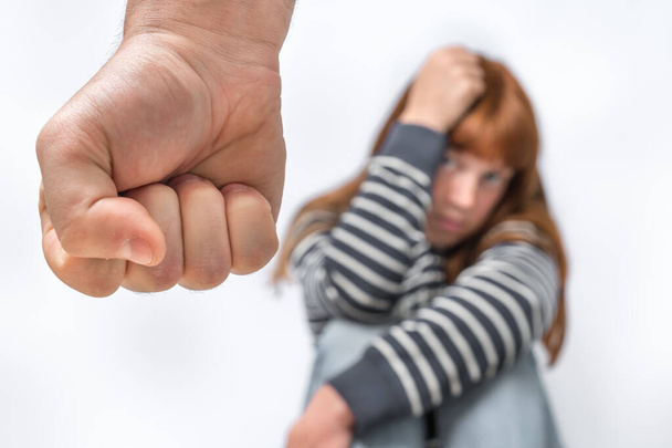 Aggressiver Mann schlägt mit Faust auf Ehefrau ein - Konzept für häusliche Gewalt - Foto, Bild
