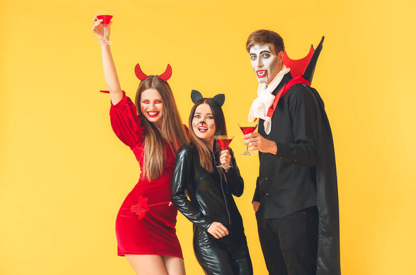 Friends in Halloween costumes on color background - Fotografie, Obrázek