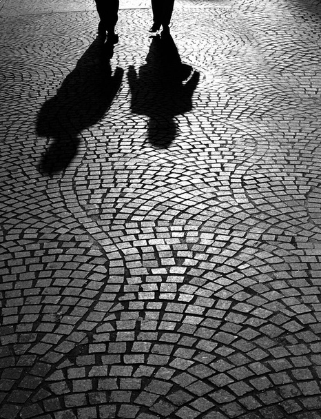 silhouetten van mensen op de oude straat in de stad - Foto, afbeelding