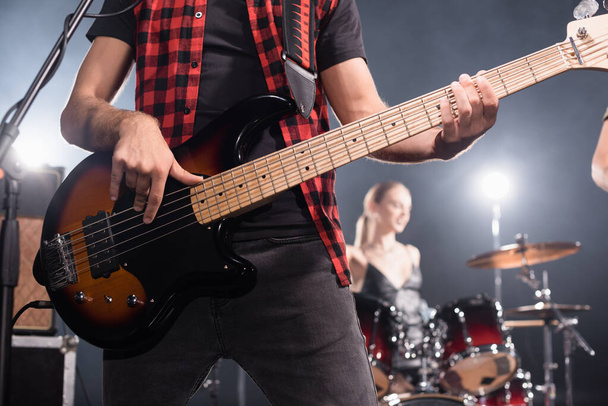 KYIV, UKRAINE - AUGUST 25, 2020: Rock band musician playing electric guitar with blurred drummer on background - Photo, Image