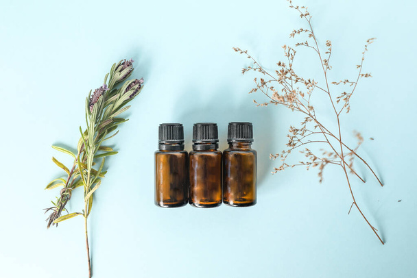 A top view of small bottles of amber essential oil on the table with plants on it - 写真・画像