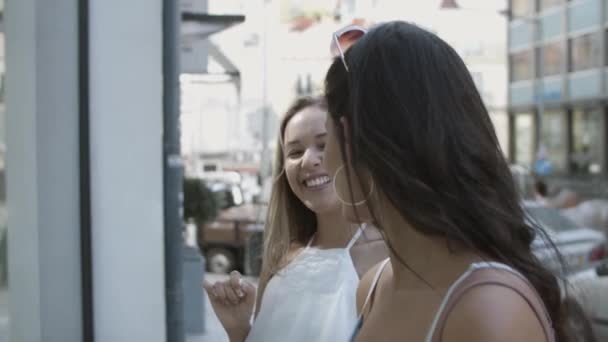 Привабливі молоді жінки розмовляють і дивляться вікно магазину
 - Кадри, відео