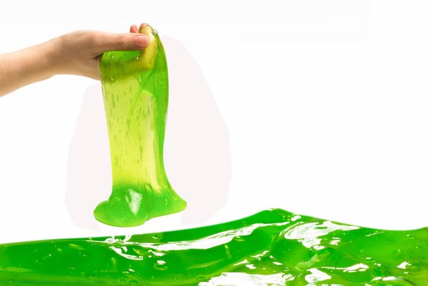 Juguete de limo verde en mano de mujer aislado en blanco. - Foto, imagen