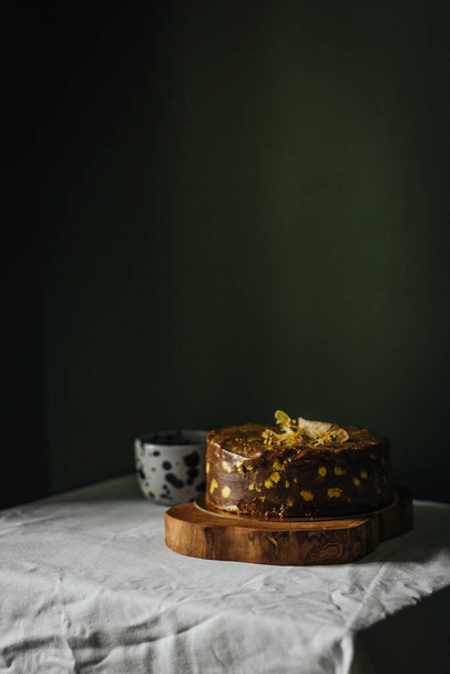 A vertical shot of a freshly baked homemade chocolate cake on a table - Zdjęcie, obraz