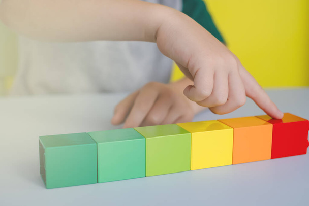 закрытие детских рук, подсчет цветных блоков в строках на столе  - Фото, изображение