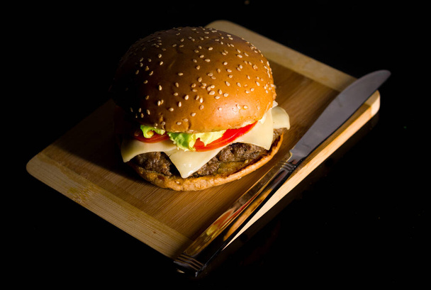A high angle shot of hamburger served on a wooden surface - Fotoğraf, Görsel