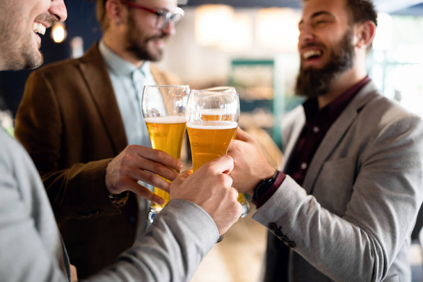 Encontro com os melhores amigos. Jovens empresários felizes conversando e bebendo cerveja em um pub - Foto, Imagem