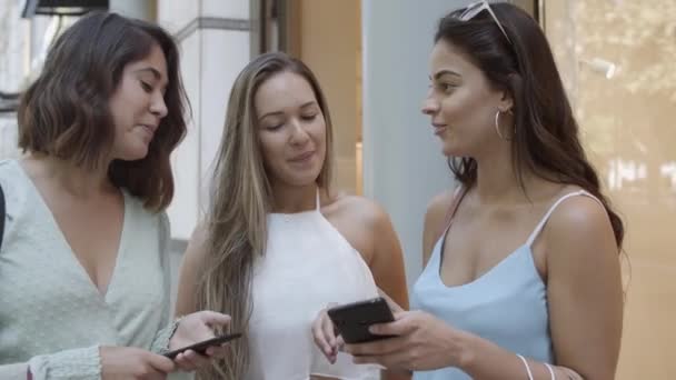 Happy best female friends using smartphones together - Footage, Video