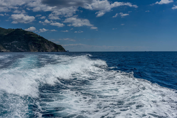 Európa, Olaszország, Cinque Terre, Monterosso, egy ember, aki hullámon lovagol egy víztesten. - Fotó, kép