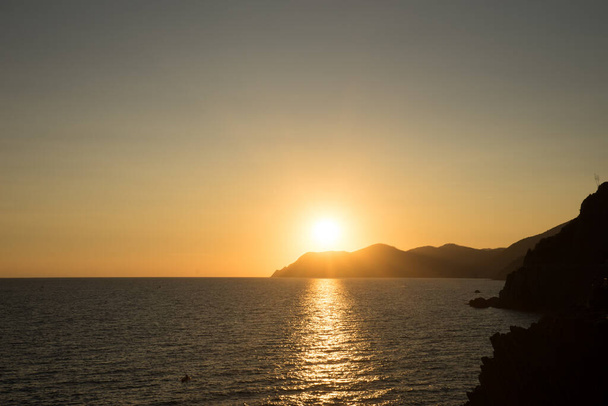 Golden sunset at the cliff at the Italian Riviera in the Village of Riomaggiore, Cinque Terre, Italy - Fotoğraf, Görsel