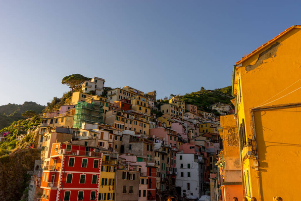 Włochy, Cinque Terre, Pejzaż Riomaggiore oglądany podczas złotej godziny zachodu słońca - Zdjęcie, obraz