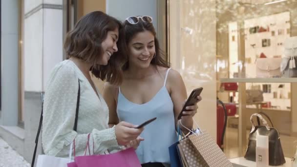 Hübsche Damen zeigen Smartphone-Bildschirme und lachen - Filmmaterial, Video