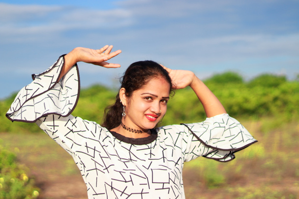 одягнений на відкритому повітрі портрет індійського молодого віку красива жінка моделі жінка відкрите ручне переду вид посміхаючись привабливе обличчя зовні - Фото, зображення