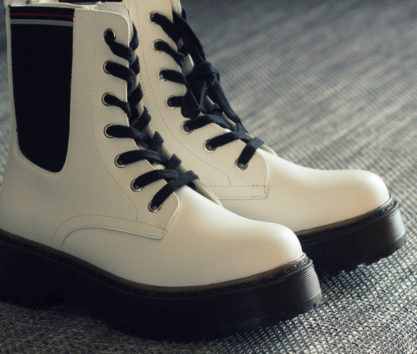 Білі шкіряні зимові чоботи на сірому фоні
 - Фото, зображення