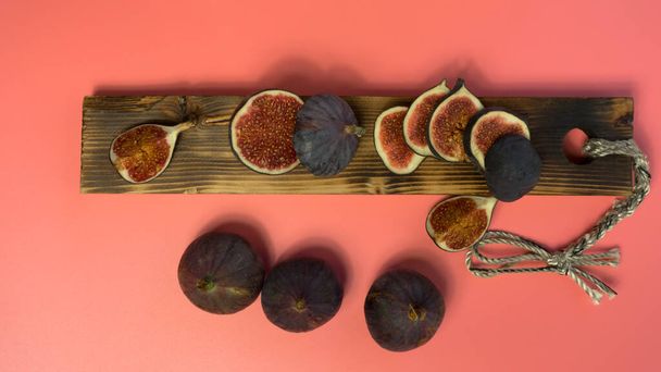 work table with blank sheets and pen, sliced fresh juicy figs, pink background. Planning concept, top view. - Photo, Image