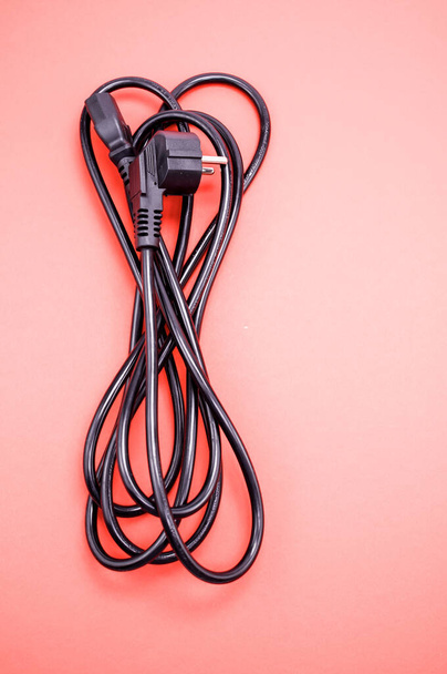 A vertical closeup of a power cable on a pink background - Photo, Image
