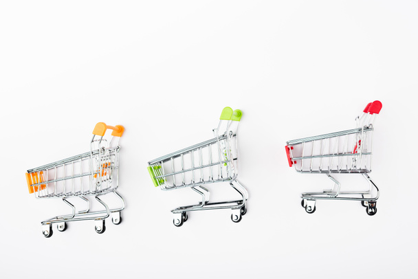 Top view of small shopping carts on white background - Φωτογραφία, εικόνα